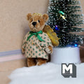 1:12 scale miniature plush angel bear in a green floral dress with gold wings, shown beside a Christmas tree