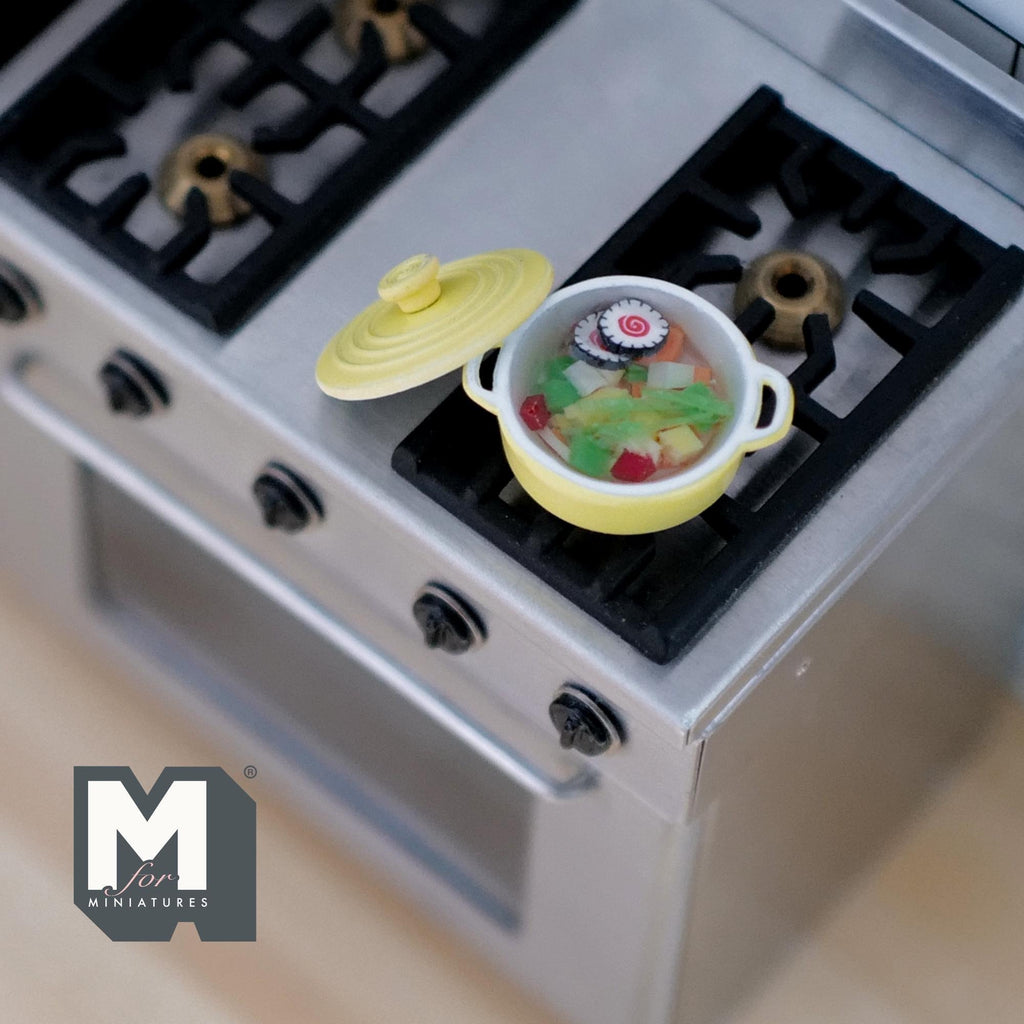 1:12 scale miniature vegetable soup in a yellow metal pot with lid, shown on a kitchen stove top