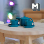 1:12 scale miniature metal pentagon teapot with cups and plates in teal, set of 5, shown on a round wood table