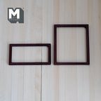 1:12 scale miniature metal photo frames in brown, set of 2, thin rectangular borders, shown on a light wood surface