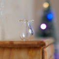 1:12 scale miniature clear glass pear shaped vase with ruffled rim, shown on a wood dresser with holiday lights behind