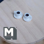 1:12 scale miniature white coffee mugs with attached saucers, set of 2, filled with dark coffee, on a round wood table