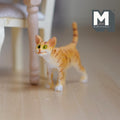 1:12 scale miniature cast resin standing ginger tabby cat with striped tail up, shown on a wood floor by a chair
