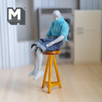 1:12 scale miniature wood pub stool in brown with round seat and splayed legs, shown with a poseable figure sitting on it