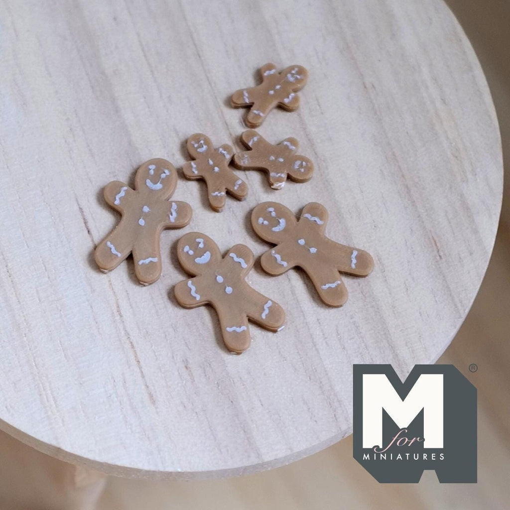 1:12 scale miniature gingerbread man cookies, set of 6, brown with white icing details, non edible, on a wood table