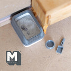 1:12 scale miniature cat litter box in gray with lid, scoop and food bowl, shown filled with litter on a floor