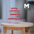 1:12 scale miniature food storage containers with clear red lids, set of 5, shown stacked on a round wood table