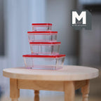 1:12 scale miniature food storage containers with clear red lids, set of 5, shown stacked on a round wood table