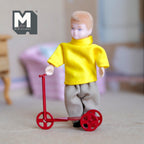 1:12 scale miniature red metal kid scooter with spoked wheels, shown with a boy doll in a yellow sweater