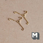 1:12 scale miniature metal clothes hangers in gold with scrolled ends, set of 2, shown on a brown surface