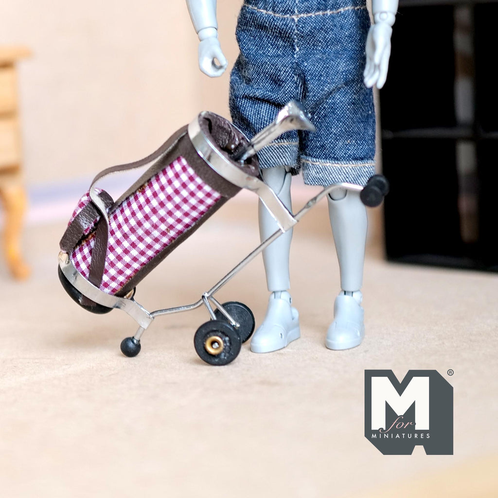 1:12 scale miniature golf bag on pull cart with 2 clubs, pink gingham faux leather, shown with a jointed figure