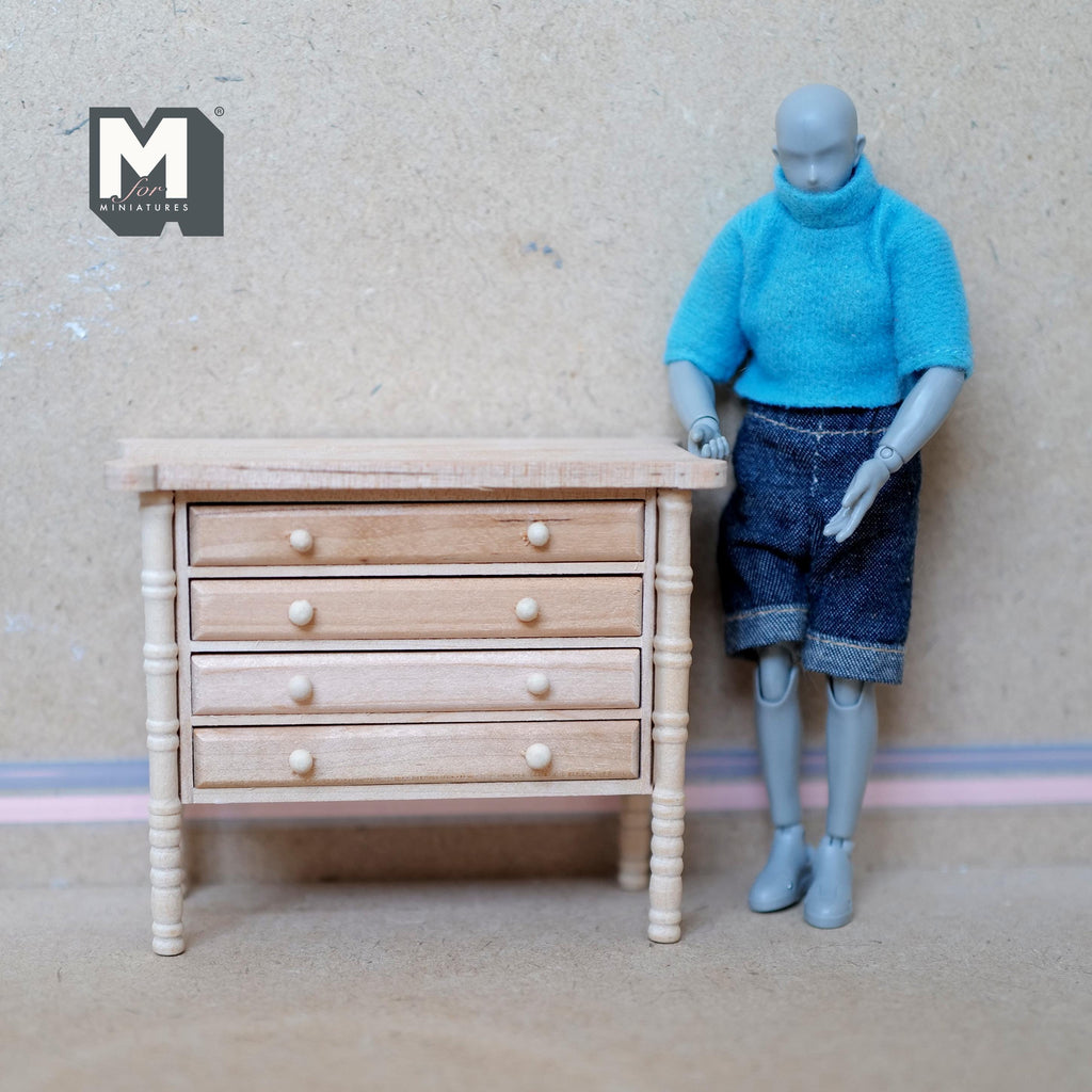 1:12 scale miniature unpainted wood chest of drawers with turned legs and 4 drawers, shown beside an artist figure