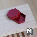 1:12 scale miniature hexagon box with lid in glossy red, shown open with the lid resting on the base on a wood table