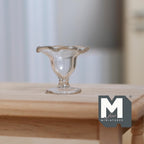 1:12 scale miniature clear glass footed fruit bowl with wavy rim, shown on a wood table