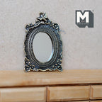 1:12 scale miniature metal oval mirror with floral frame and bird on top, antique silver tone, shown on a wood dresser