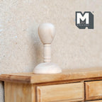 1:12 scale miniature wood mannequin head hat stand with round base, unfinished light wood, shown on a wood dresser