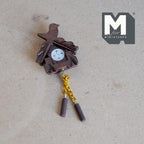 1:12 scale miniature wood cuckoo clock in brown with a carved bird, gold chains and weights, shown lying flat