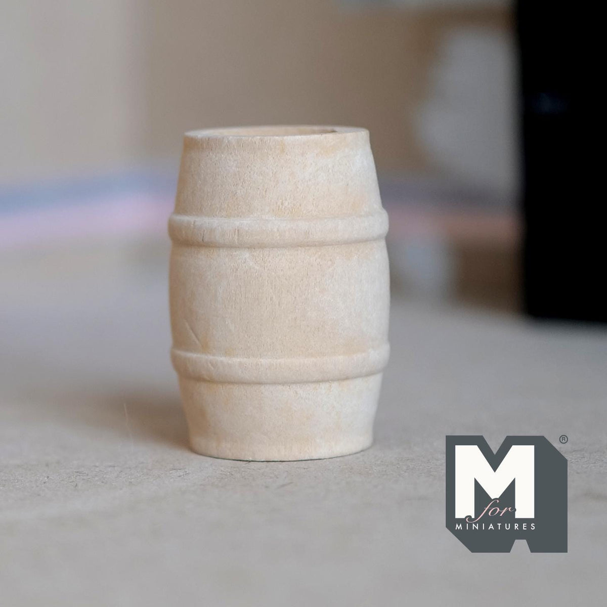 1:12 scale miniature wood wine barrel, medium, unfinished pale wood with raised bands, shown on a gray floor