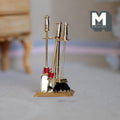 1:12 scale miniature brass fireplace tool set with stand, poker, shovel and brush, shown on a carpet floor