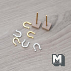 1:12 scale miniature horseshoe pitching game set with gold and silver horseshoes and two stakes, shown on wood