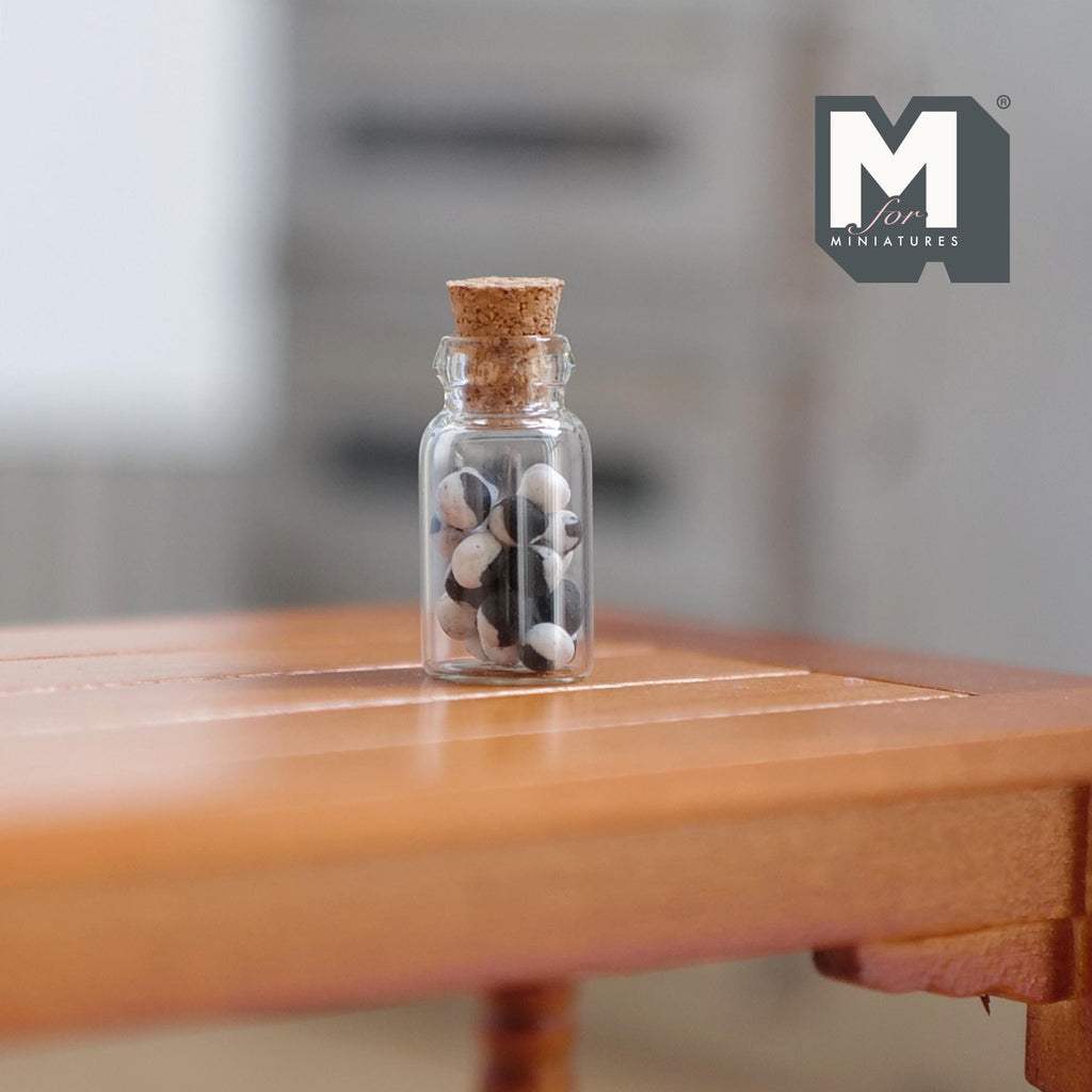 1:12 scale miniature glass jar of humbug candies with cork lid, black and white striped sweets, shown on a wood table