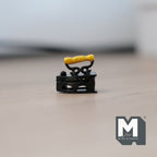 1:12 scale miniature black metal classic flat iron with a gold handle on a trivet stand, shown on a wood surface
