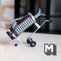1:12 scale miniature golf bag on pull cart with 2 clubs, navy gingham faux leather with brown trim, on a wood floor