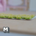 1:12 scale miniature assorted flower clusters in green, set of 32, grassy tufts shown in a row on a backing sheet