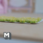 1:12 scale miniature assorted flower clusters in green, set of 32, grassy tufts shown in a row on a backing sheet
