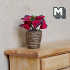 1:12 scale miniature red poinsettia in a twine wrapped pot, shown on a wood dresser