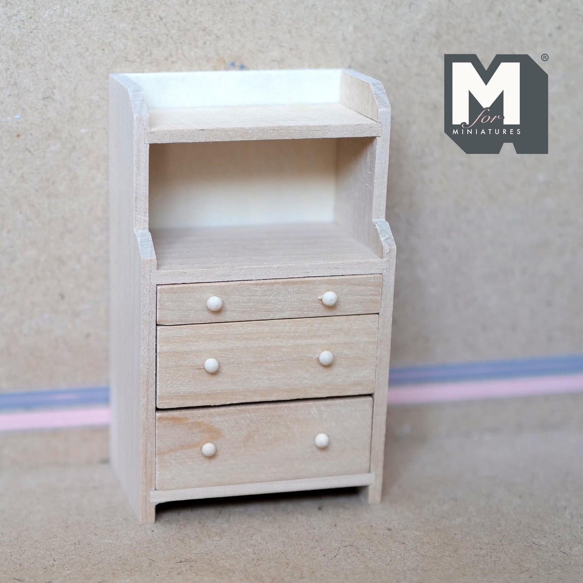 1:12 scale miniature unpainted wood bureau with 3 drawers and open shelf above, white knobs, shown against a wall