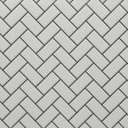 Miniature white embossed herringbone subway tile sheet with black grout, close-up of the tile pattern