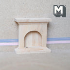 1:12 scale miniature unpainted wood fireplace surround with arched opening and mantel shelf, against a plain wall