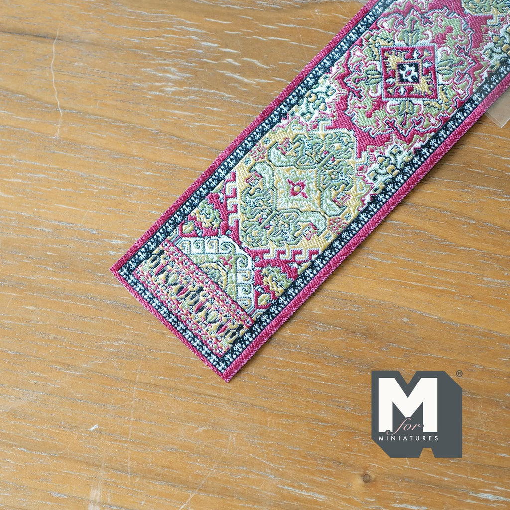 1:12 scale miniature fabric stair runner in red with medallion pattern and fringe, shown on a wood floor
