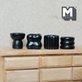 1:12 scale miniature black resin sculptural vases in four different shapes, set of 4, lined up on a wood dresser