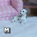 1:12 scale miniature cast resin lying Dalmatian dog, white with black spots, shown on a white rug by a pink sofa