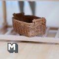 1:12 scale miniature light brown resin rattan style basket with handles, rectangular woven look, shown on a wood shelf
