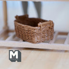 1:12 scale miniature light brown resin rattan style basket with handles, rectangular woven look, shown on a wood shelf