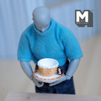 1:6 scale miniature waffle pattern cup and saucer, set of 2, tan cup on a white saucer, held by a poseable figure