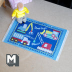 1:12 scale miniature construction vehicle rug in blue, playroom play mat with trucks and crane, shown with a toddler doll