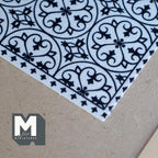 1:12 scale miniature printed area rug sheet with black and white geometric tile pattern, corner close-up