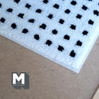 1:12 scale miniature black and white dotted grid area rug, close view of the corner with black dots on white pile