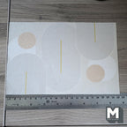 1:12 scale miniature beige printed geometric area rug with circles and curved lines, shown with a ruler