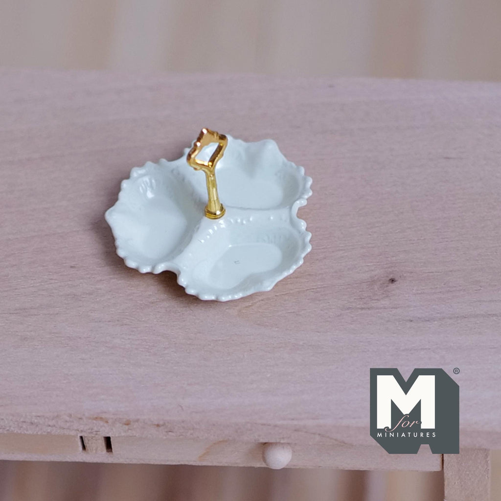 1:12 scale miniature 3 compartment serving dish in cream with scalloped edge and gold center handle, on a wood table