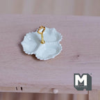 1:12 scale miniature 3 compartment serving dish in cream with scalloped edge and gold center handle, on a wood table