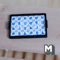1:12 scale miniature wood Delft tile tray in blue and white with a black frame and side handles, on a wood table