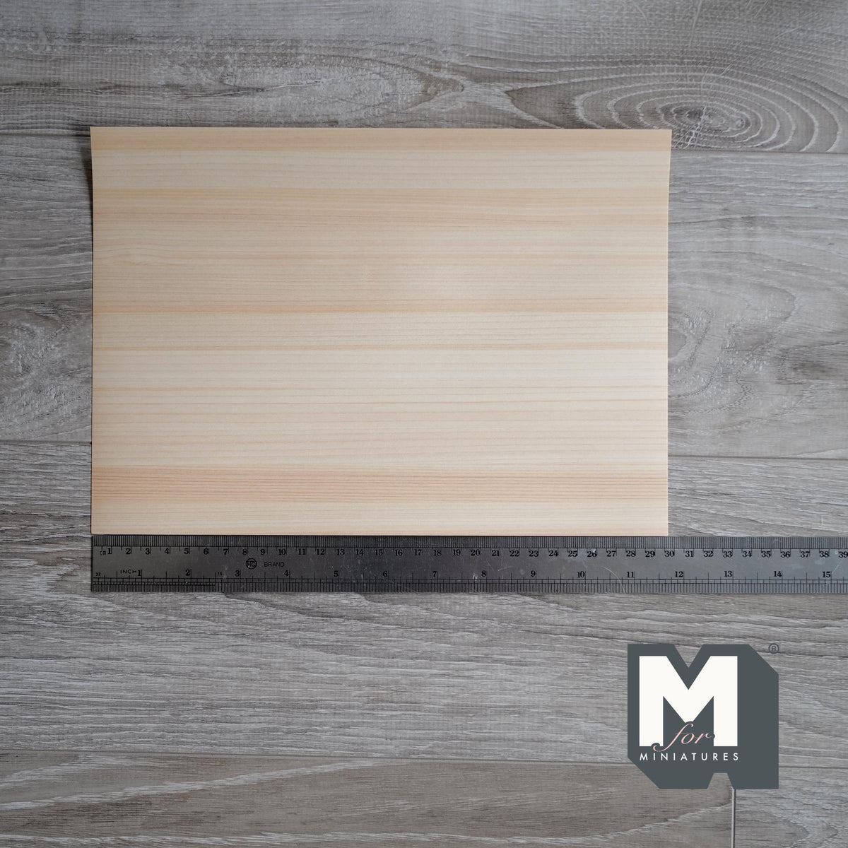 Miniature hinoki cypress peel and stick wood veneer sheet for floors, walls and crafts, pale cream grain, shown with a ruler