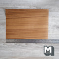 Miniature teak peel and stick wood veneer sheet, warm golden brown straight grain, shown with a ruler for scale