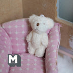 1:12 scale miniature fuzzy plush teddy bear doll in white with a brown nose, shown sitting on a pink armchair