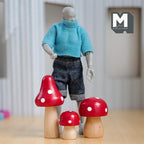 1:12 scale miniature wood fairy mushrooms with red caps and white dots, set of 3, shown beside an artist figure